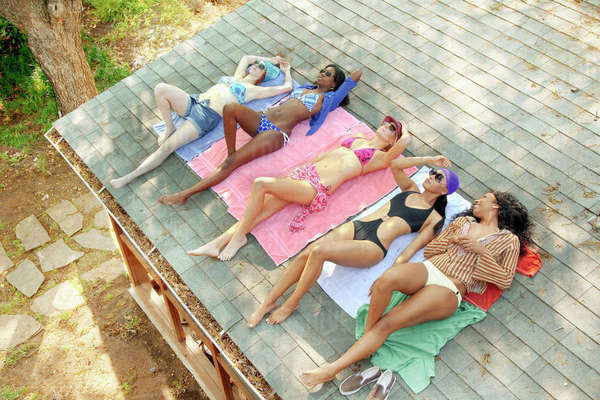 The SPF 30 Habit I Overlooked That Made Skincare Simple Young woman sunbathing on the roof.